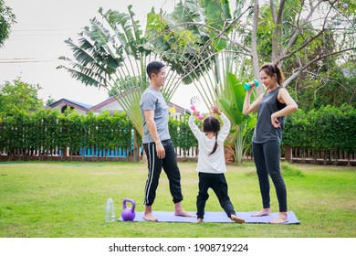 Fit Happy People Working Out Outdoor. Family Asian Parent And Child Daughter Exercising Together On A Yoga Mat At Home Garden. Family Outdoors. Exercise At The Home Concept And New Normal.

