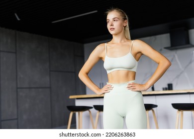 Fit Happy Woman In Sportswear With Hands On Hips At Home In Bright Room