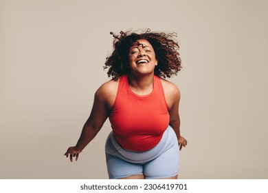 Fit having a blast in a dance workout, a lively and expressive physical activity. Woman celebrating her body, flaunting her confidence, and allowing herself to be fully expressed through body movement - Powered by Shutterstock