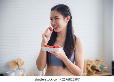 Fit And Healthy Young Asian Woman In Sportswear Preparing And Drinking Fresh Lemon Water For Healthy Lifestyle And Fitness In Modern Kitchen After Morning Workout And Exercise At Home