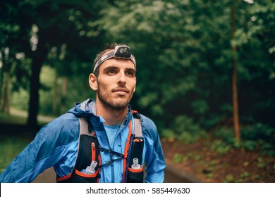 Fit male jogger with a headlamp rests during training for cross country trail race in nature park. - Powered by Shutterstock