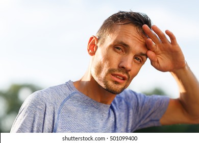 Fit Man Bent Head And Wipes Forehead With His Fingers