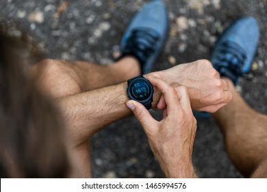Fit man checking smart watch wearable technology sport smartwatch on fitness run walk outside. Top view from above with running shoes in street. - Shutterstock ID 1465994576