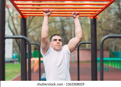 Fit Man Cross Training On Monkey Bars . Fitness Workout On Brachiation Ladder In An Outdoor Gym Outside.