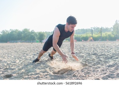 Fit man doing clapping push-ups during training exercise workout on beach in summer.
