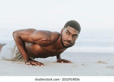 Fit man doing pushups in the sand