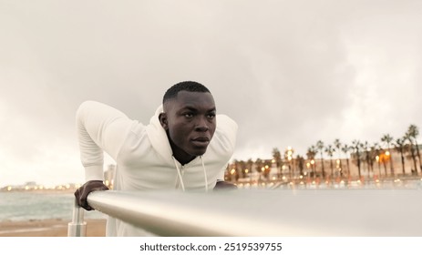 Fit man doing triceps dips on parallel bars outdoors, an athlete exercises on the bars during a street workout, healthy lifestyle and street sport concept - Powered by Shutterstock