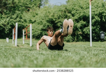 Fit man exercising in nature, performing leg raises on a grassy field. Outdoor fitness and workout concept - Powered by Shutterstock