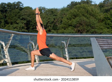 Fit Man Hold Virabhadrasana Pose Doing Crescent Lunge Stretch On Promenade, Yoga