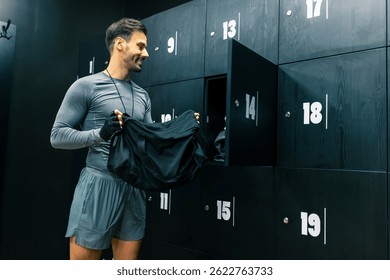 El hombre en forma pone sus cosas en el vestuario del gimnasio.