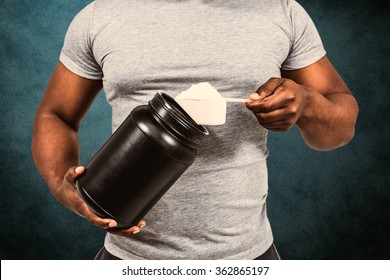 Fit Man Scooping Protein Powder Against Blue Background