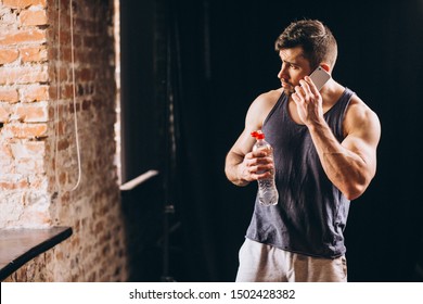 Fit Man Talking On The Phone At The Gym