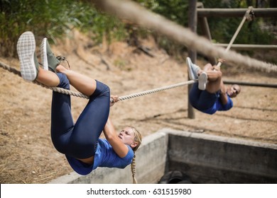 Fit man and woman crossing the rope during obstacle course in boot camp - Powered by Shutterstock