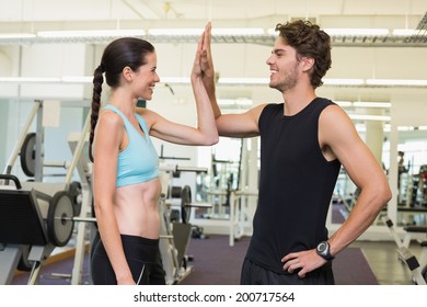 Fit Man And Woman High Fiving At The Gym