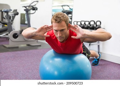 Fit Man Working His Core On Exercise Ball At The Gym