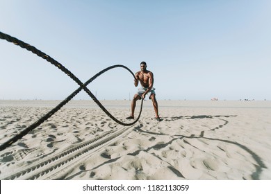 Fit man working out with battle ropes - Powered by Shutterstock