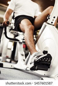 Fit Man Working Out On Exercise Bike At The Fitness. Healthy And Funny Lifestyle Concept.