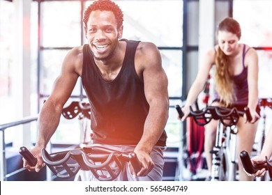 Fit Man Working Out At Spinning Class In Gym