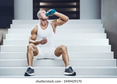 Fit Man At Workout In Gym With Shaker. Bodybuilding And Healthy Lifestyle Concept Background. Muscular Bodybuilder With Sport Nutrition Supplements Jar In Gym Naked Torso