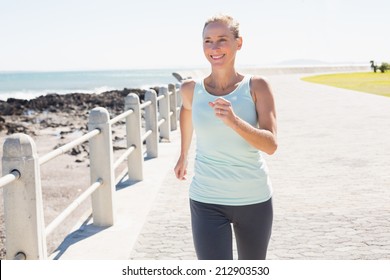 Fit Mature Woman Jogging On The Pier On A Sunny Day