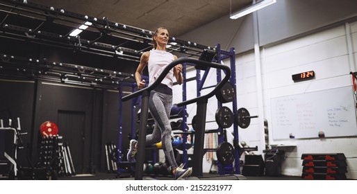 Fit mature woman in sportswear jogging on a treadmill during a cardio workout at the gym - Shutterstock ID 2152231977