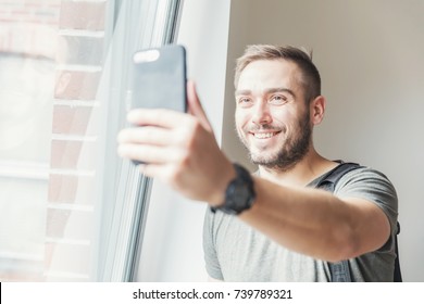 Fit Millenial Man Taking A Selfie In The Daylight, Holding A Phone In His Hand.