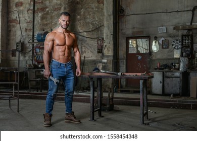 Fit muscled half naked man at work in an old factory.