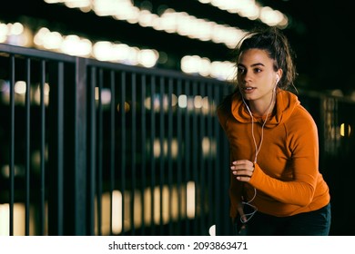 A fit night runner running fast on the railroad station at night. Night fitness, night running - Powered by Shutterstock