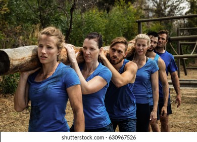 Fit People Carrying A Heavy Wooden Log During Boot Camp Training