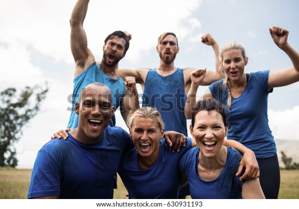 Fit people cheering\
together in boot camp