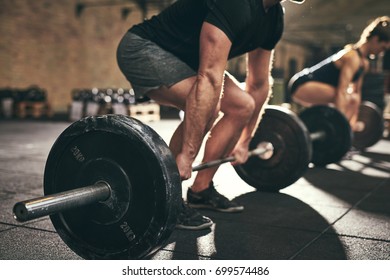 Fit people doing deadlift exercise in gym. Horizontal indoors shot - Shutterstock ID 699574486
