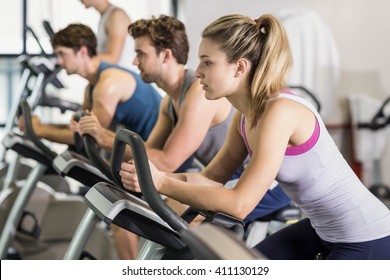 Fit people doing exercise bike at gym - Powered by Shutterstock