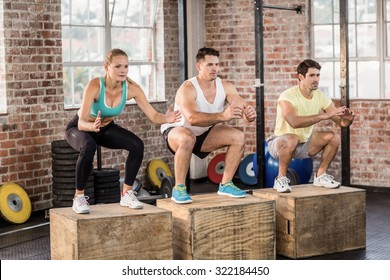 Fit People Doing Jump Box In Crossfit Gym