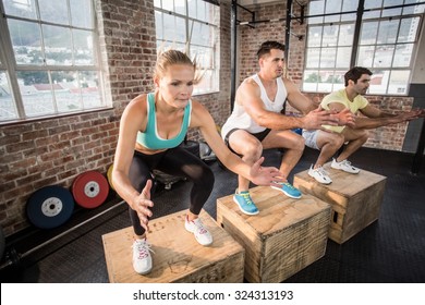 Fit People Doing Jump Box In Crossfit Gym