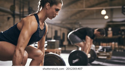 Fit people preparing to deadlift and holding barbells. Horizontal indoors shot - Shutterstock ID 2012301407