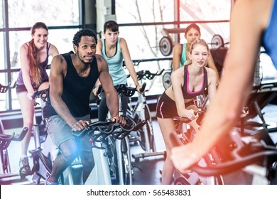 Fit People Working Out At Spinning Class In Gym