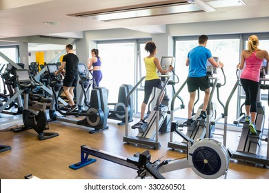 Fit People Working Out Using Machines At The Gym