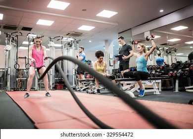 Fit People Working Out In Weights Room At The Gym