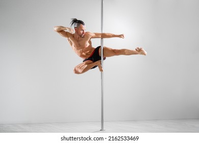 Fit pole athlete does trick on the pole, pole dancing 