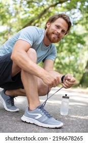 Fit Runner Man Getting Ready To Run Tying Shoe Laces