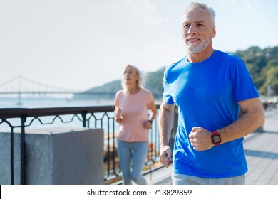 Fit senior man jogging together with his wife