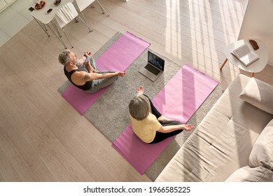 Fit Senior Old Couple Doing Virtual Yoga Class Breathing Exercises Together At Home, Top View. Mature Mid Age Man And Woman Meditating Watching Fitness Training Digital Online Tv Video On Laptop.