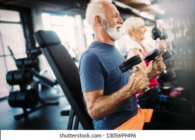Fit Senior Sporty Couple Working Out Together At Gym