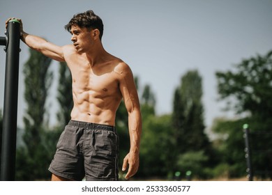 Fit shirtless man resting after a rigorous outdoor workout on a sunny day, showcasing his toned muscles and athletic physique. - Powered by Shutterstock