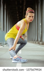 Fit Sports Woman In Fitness Clothes On Pont De Bir-Hakeim Bridge In Paris Stretching.