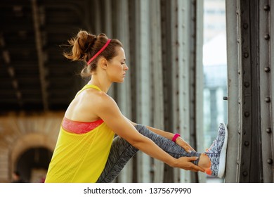 Fit Sports Woman In Fitness Clothes On Pont De Bir-Hakeim Bridge In Paris Stretching.