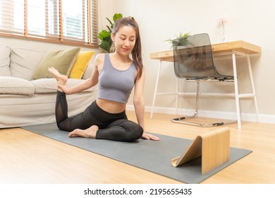 Fit, Sporty Asian Young Woman In Sportswear Sitting On Floor, Exercise On Mat, Watching Online Training Videos On Tablet In Living Room At Home. Workout Fitness, Pilates For Wellbeing, Healthy Care.