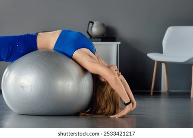 Fit sporty healthy woman exercising her abs on pilates ball, Health journey at home: A woman with long hair focuses on solo fitness for well-being - Powered by Shutterstock