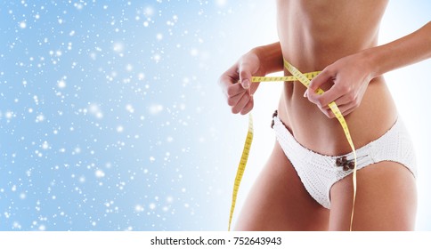Fit And Sporty Woman With Beautiful And Slender Body Over Seasonal Christmas Background With Winter Snow. Health, Diet And Sport Concept.