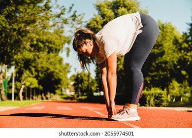 Fit sporty young plump plus-size body positive woman athlete stretching before yoga class training losing weight in fitness outfit in stadium